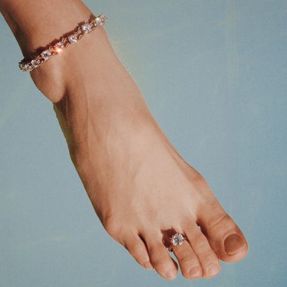 a woman wearing an AFLALO and Leandra Medine Cohen diamond toe ring and diamond anklet