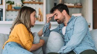 Woman and man sat together on couch