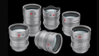 A collection of six silver camera lenses arranged artistically against a black background, showcasing their sleek designs and glass components