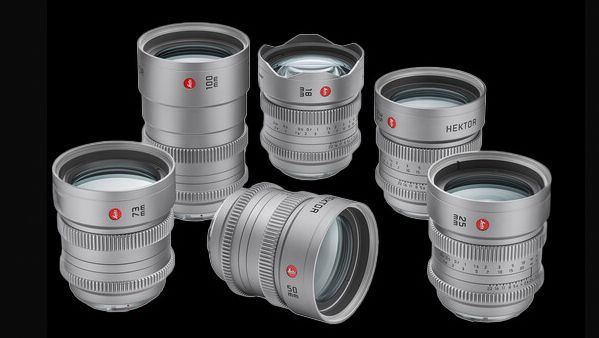 A collection of six silver camera lenses arranged artistically against a black background, showcasing their sleek designs and glass components