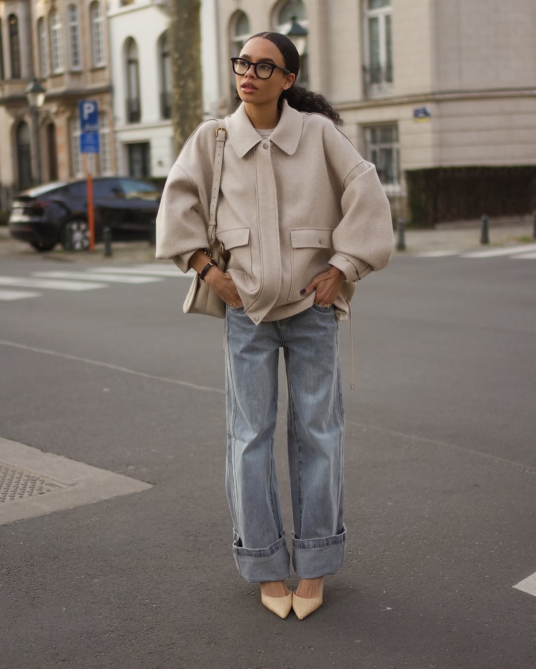 @iamzoefoster wears light blue cuff-hem jeans with a cream jacket and heels