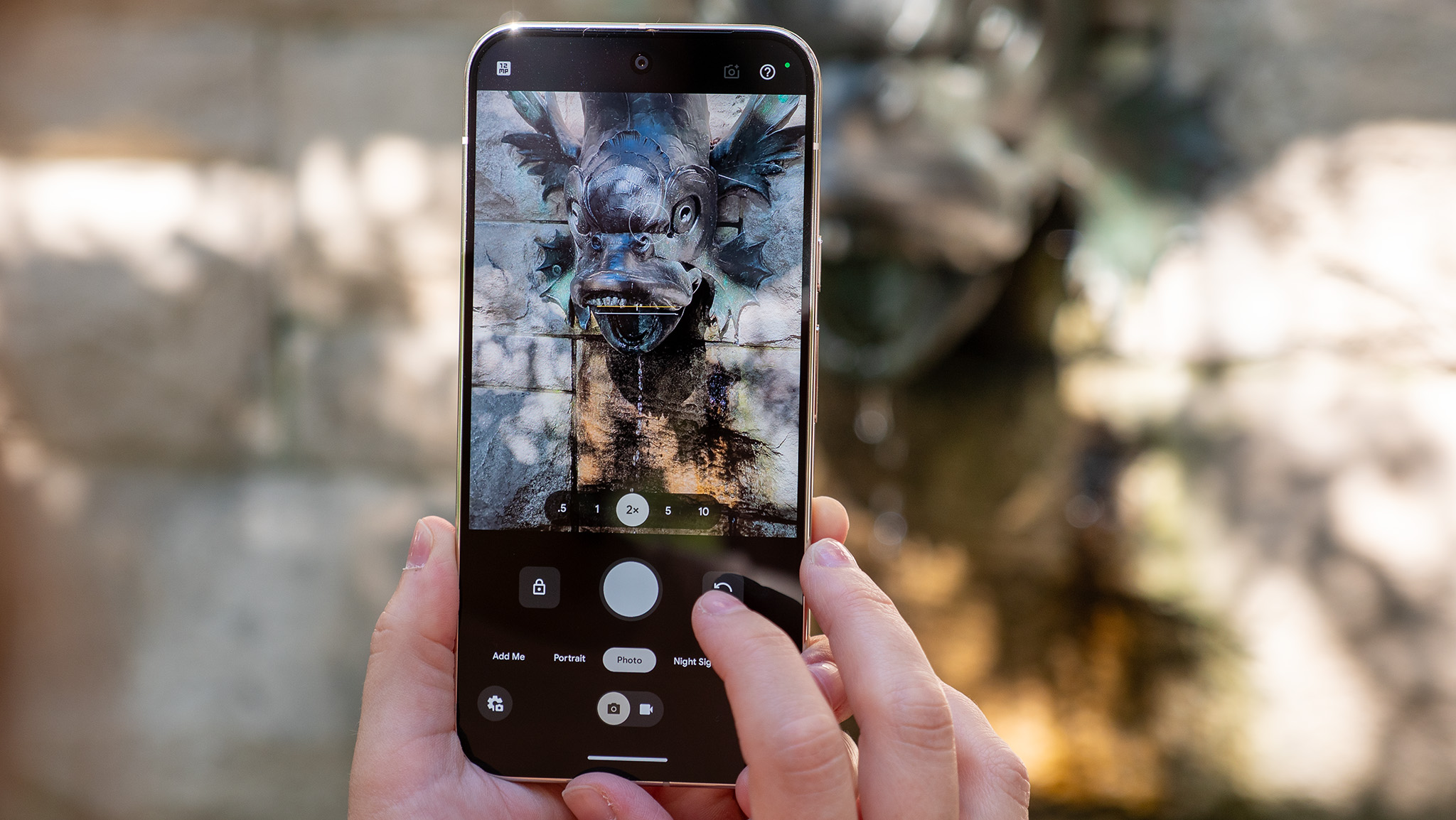 Using a Google Pixel 10 Pro XL to take a photo of a stone fish fountain