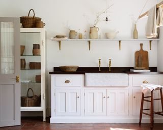 scullery with tiled flooring and white cabinets