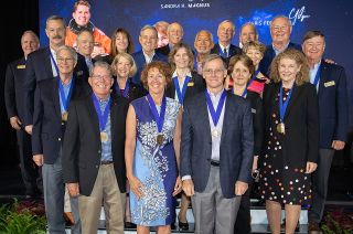 David Leestma, Sandra Magnus and Chris Ferguson stand with prior inductees after being enshrined into the U.S. Astronaut Hall of Fame at Kennedy Space Center Visitor Complex in Florida on Saturday, June 11, 2022. Behind them, from left to right: Tom Jones, Scott Altman, John Blaha, Charlie Precourt, Janet Kavandi, Pam Melroy, Bob Cabana, Dick Covey, Bonnie Dunbar, Charlie Bolden, Curt Brown, Kathy Thornton, John Grunsfeld, Eileen Collins, Jerry Ross, Susan Helms and Frank Culbertson.
