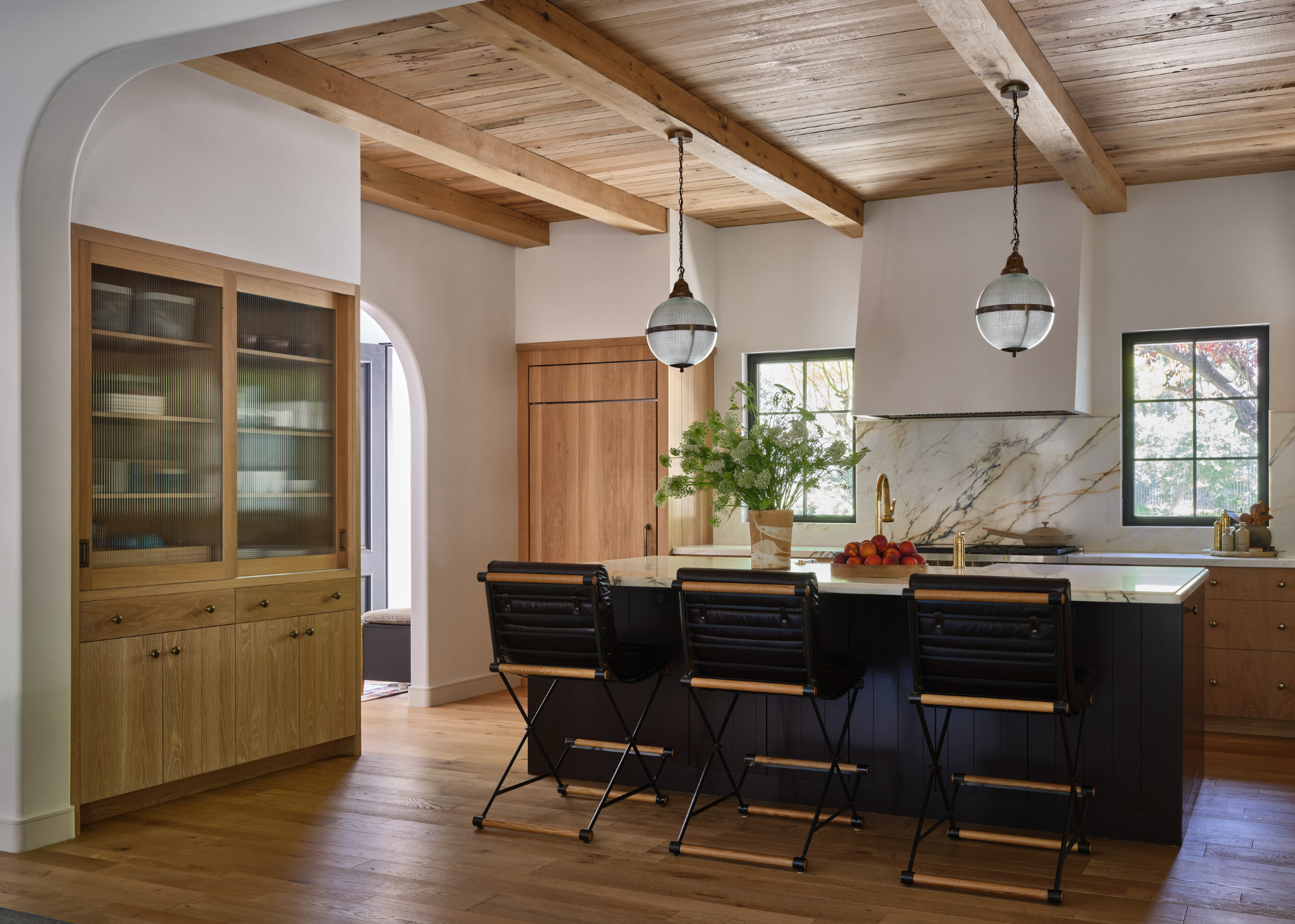 Open plan kitchen with wooden beams ceiling and dark cabinetry
