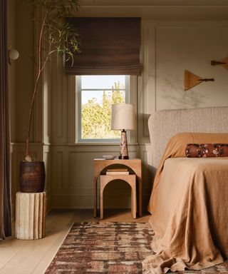 modern warm neutral bedroom with a patterned rug under the bed and decorated in a japandi style