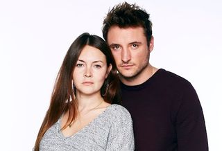 Headshot of Stacey and Martin in EastEnders, both wearing jumpers and looking serious