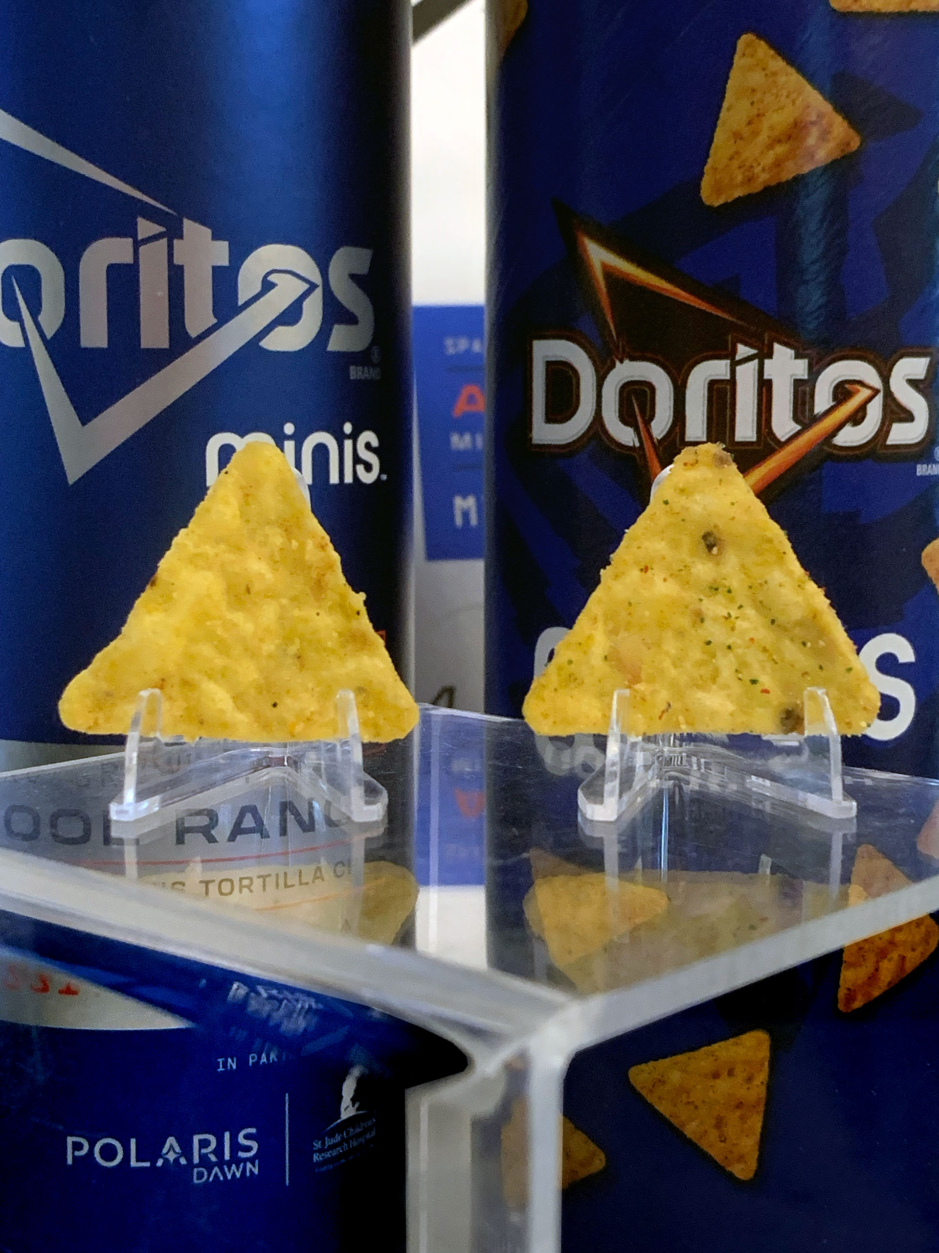 closeup of two triangular doritos chips on clear plastic stands