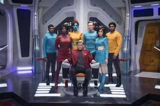 Seven crew members inside a futuristic starship