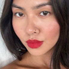 A woman taking a selfie wearing a bold red lip