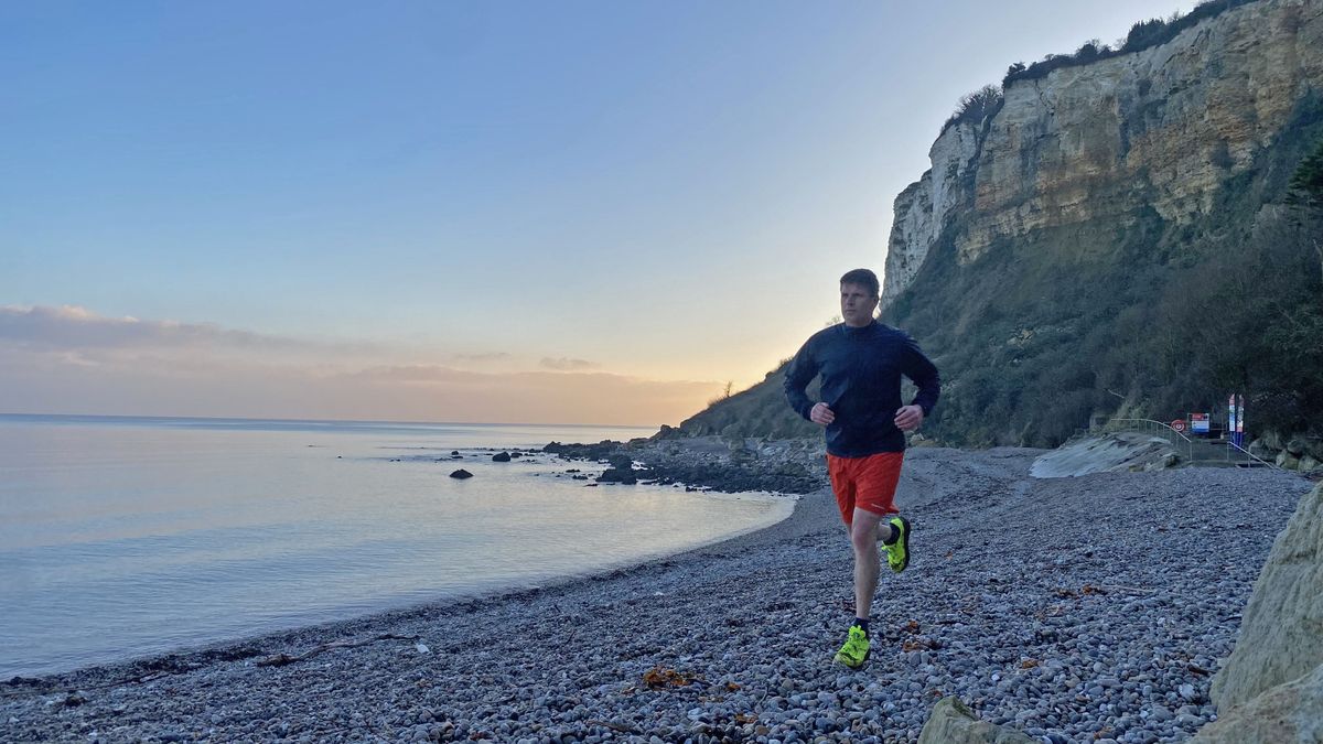 man running along a beach in Saucony Xodus Ultra 3 shoes