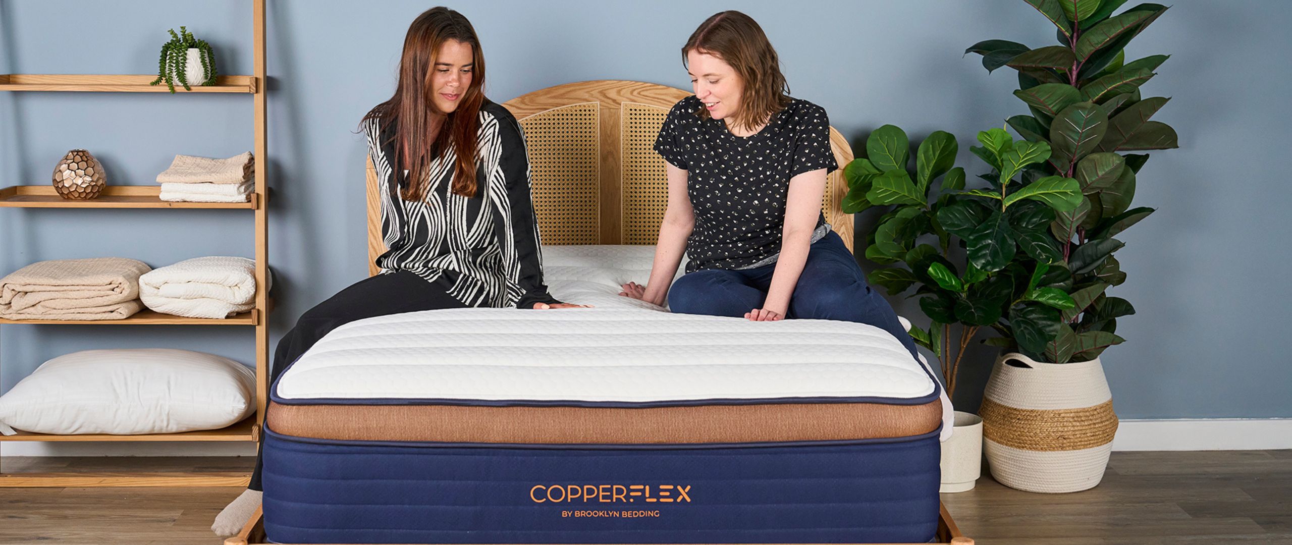 Two Tom&#039;s Guide mattress testers sitting on the Brooklyn Bedding CopperFlex Pro Hybrid mattress for the review