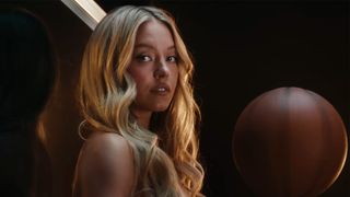 Sydney Sweeney sits on a basketball hoop and stares at the camera in viral "Just Sports" Novig ad.