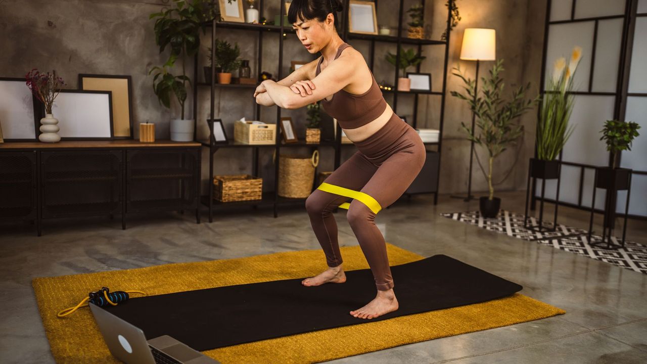 woman using one of the best pilates bands - getty 2148871870