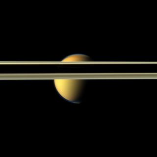 NASA's Cassini spacecraft gets a view of Titan obscured by Saturn's rings. A shadow cast by the planet makes parts of the rings near the center of the image appear dark.