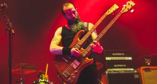 Jeff Matz plays a doubleneck bass on a stage lit up in red