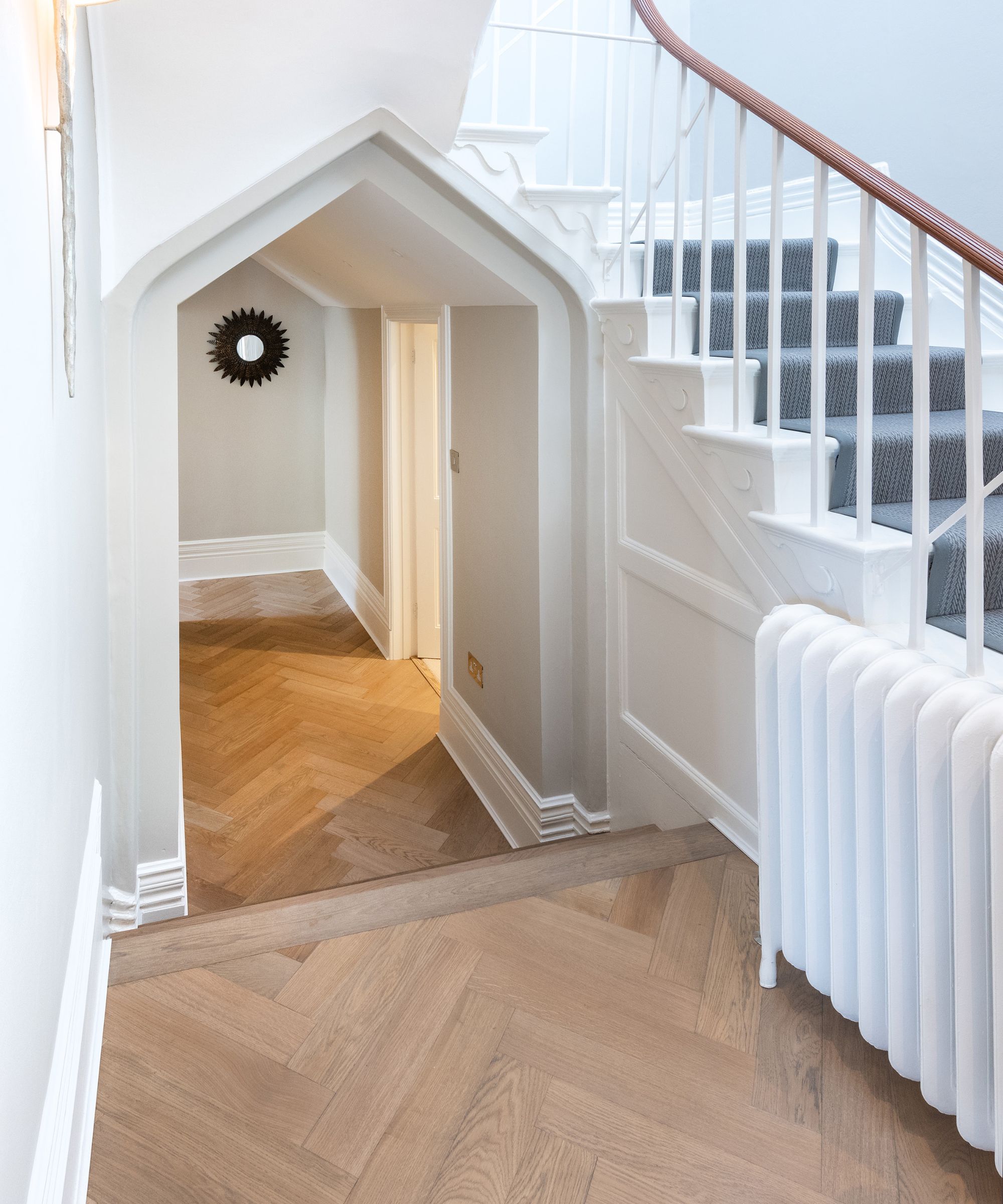 A hallway with an elegant archway and light wooden floors