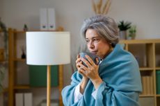 Senior woman warming up with hot drink