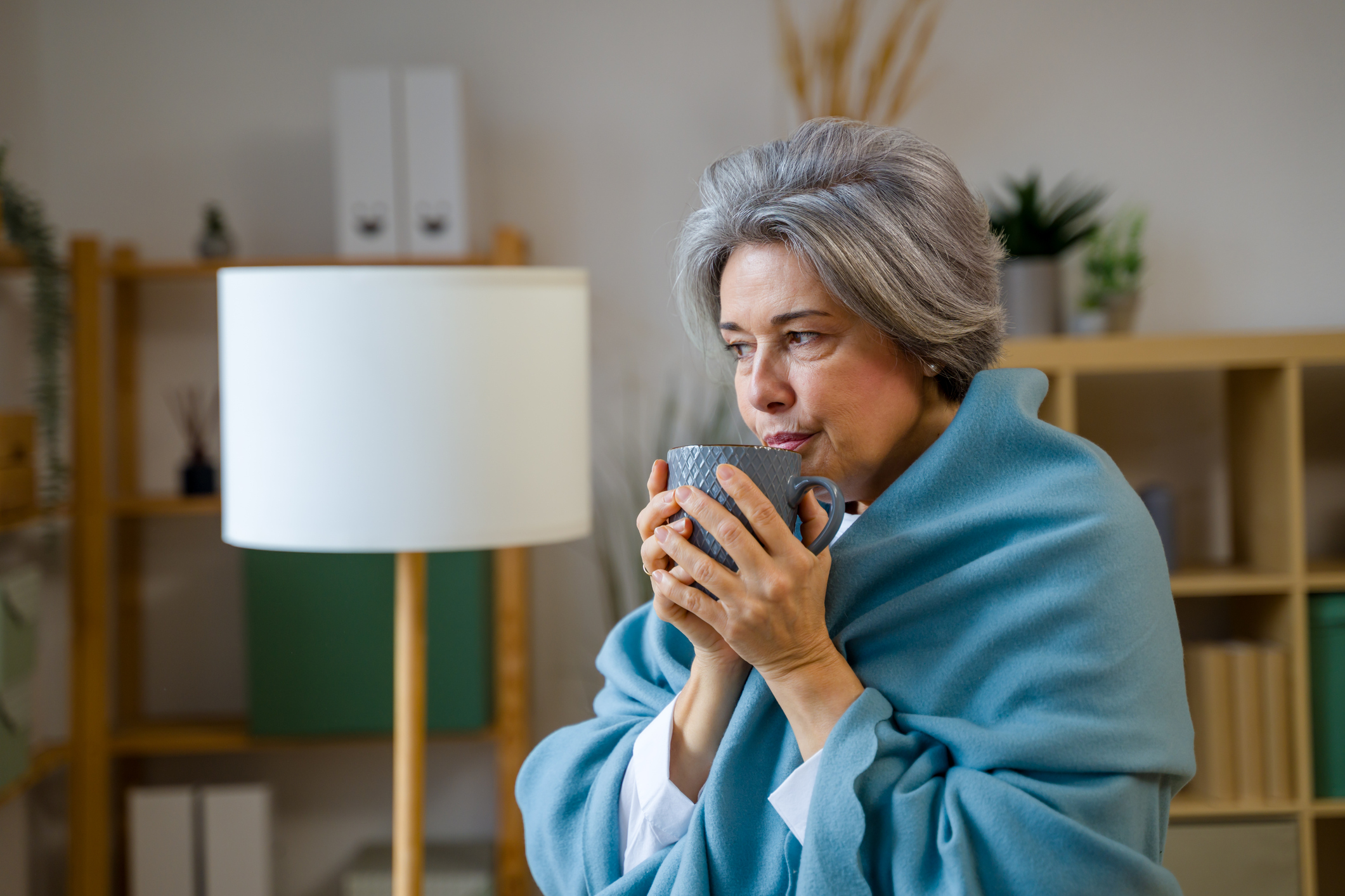 Senior woman warming up with hot drink
