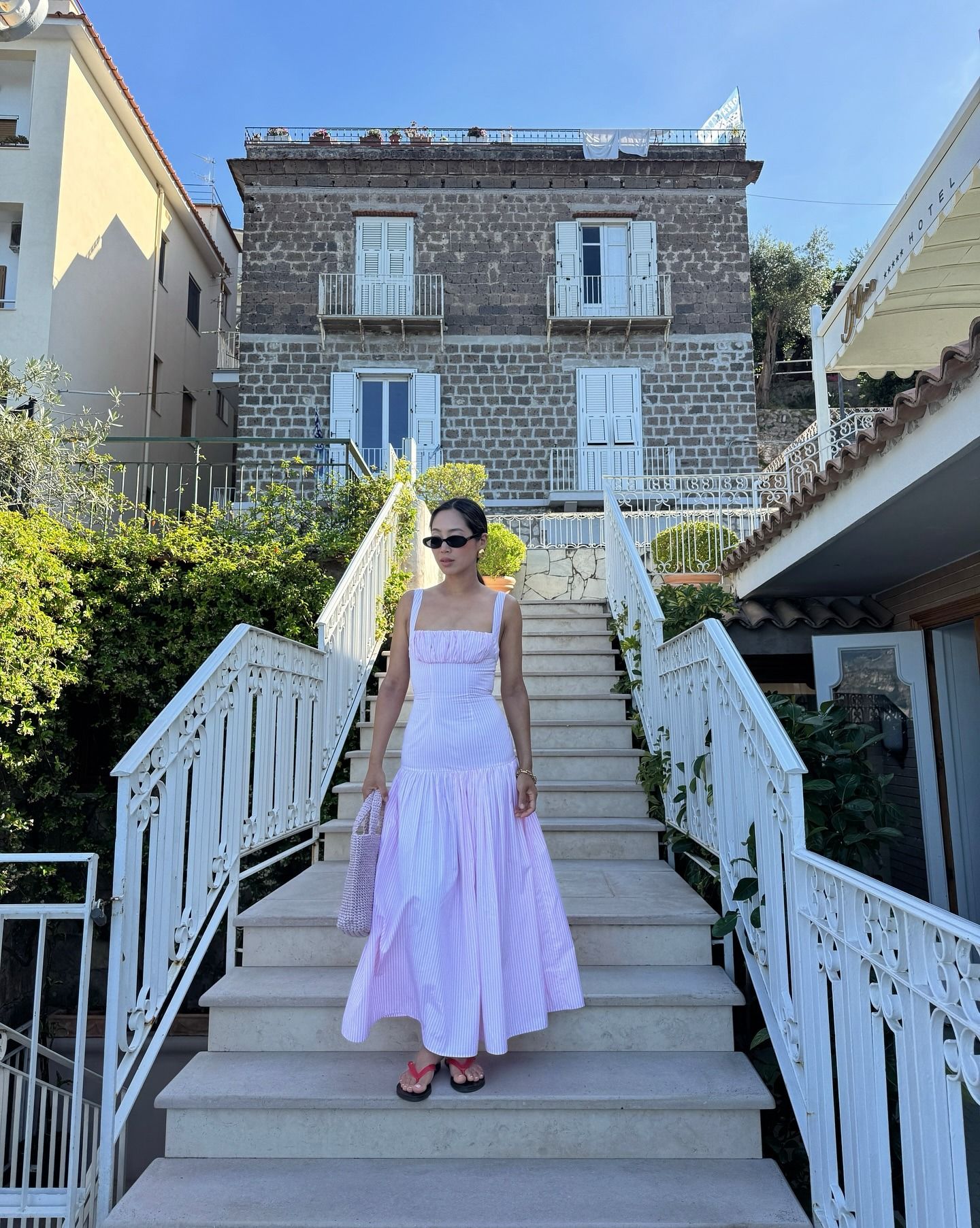 Influencer wearing a maxi dress and sandals in Italy.
