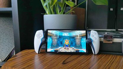 PlayStation Portal on woodgrain table next to plant