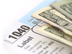 Twenty dollar bills on an IRS 1040 tax form