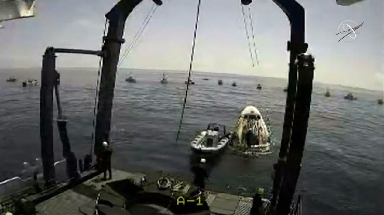 SpaceX hoists the Demo-2 Crew Dragon capsule Endeavour from the Gulf of Mexico while private boaters watch nearby off the coast of Pensacola, Florida on Aug. 2, 2020.