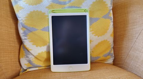 A RIchgv LCD Writing Tablet sitting against a yellow cushion