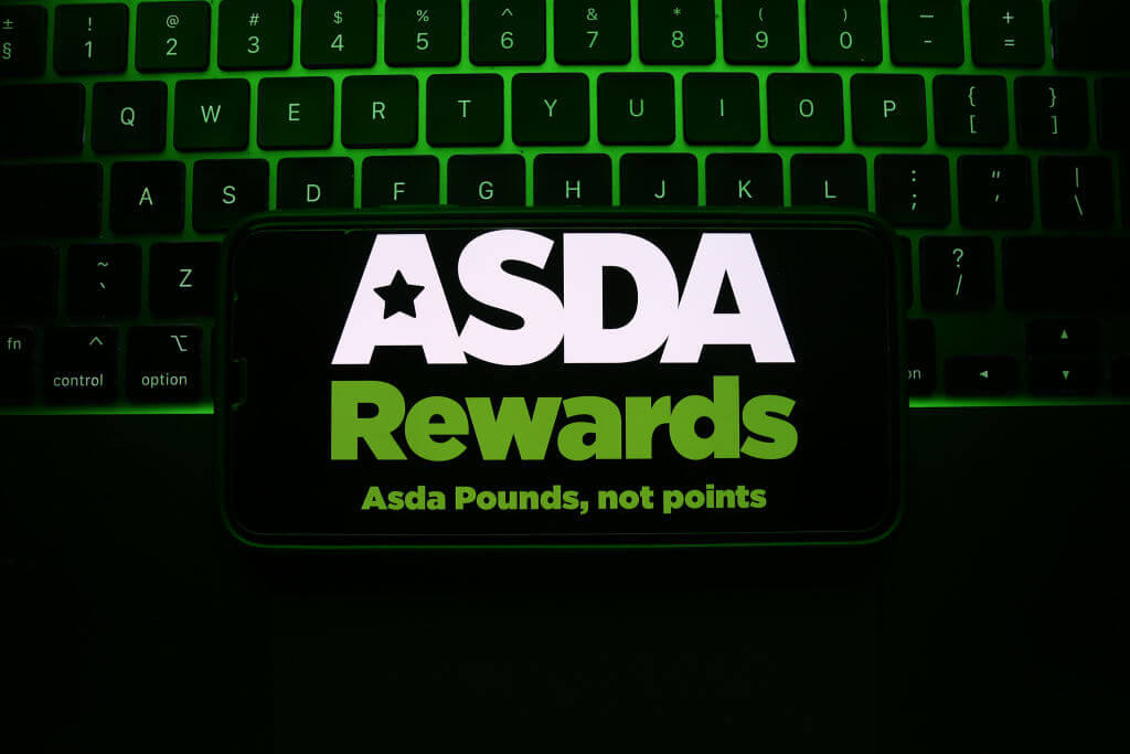 ASDA Rewards logo in white and green in front of a keyboard with green LEDs 