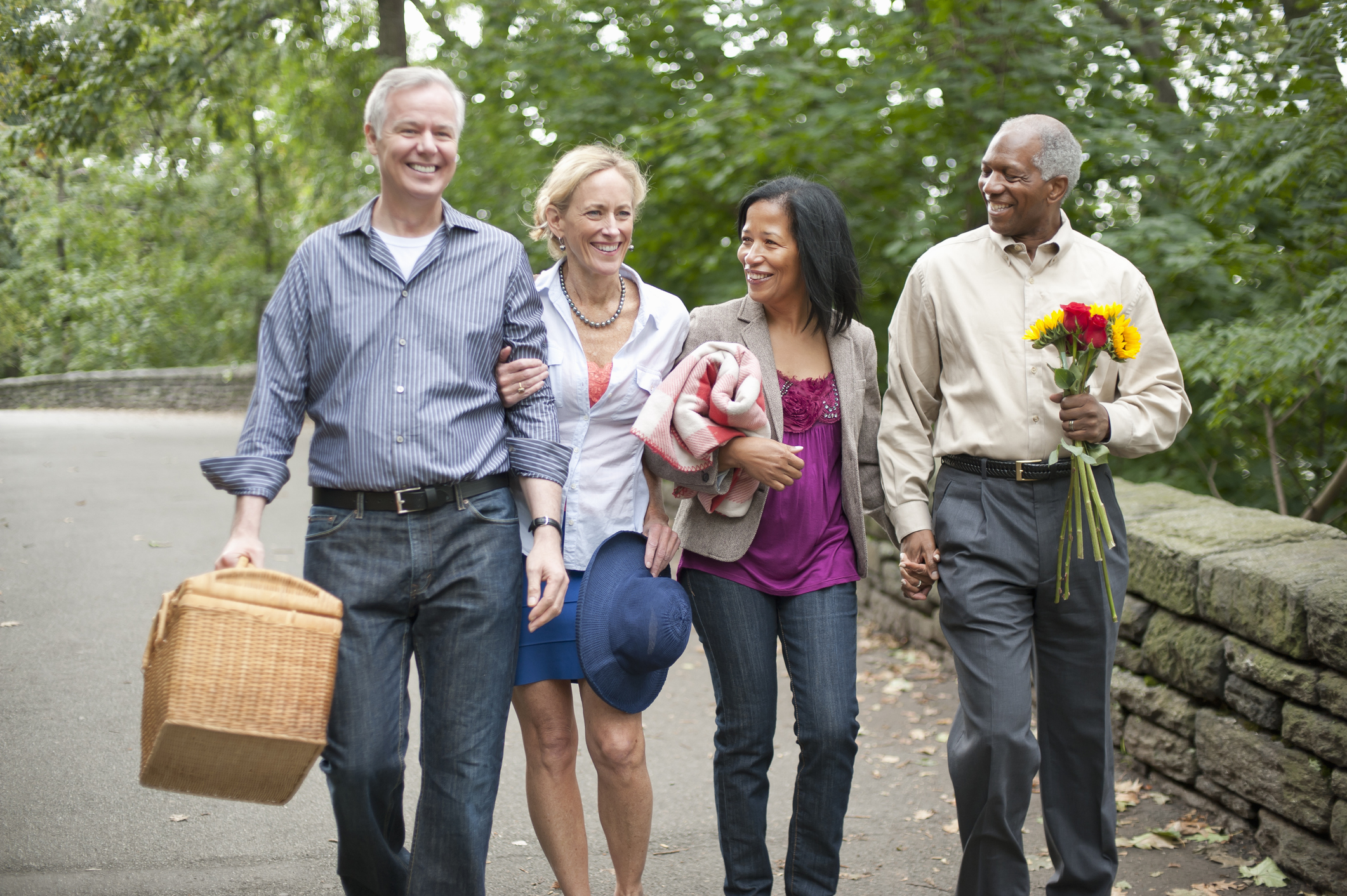 Older friends with picnic basket in park