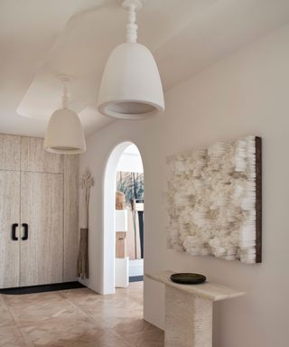 organic modern entryway with console table and large storage cupboards