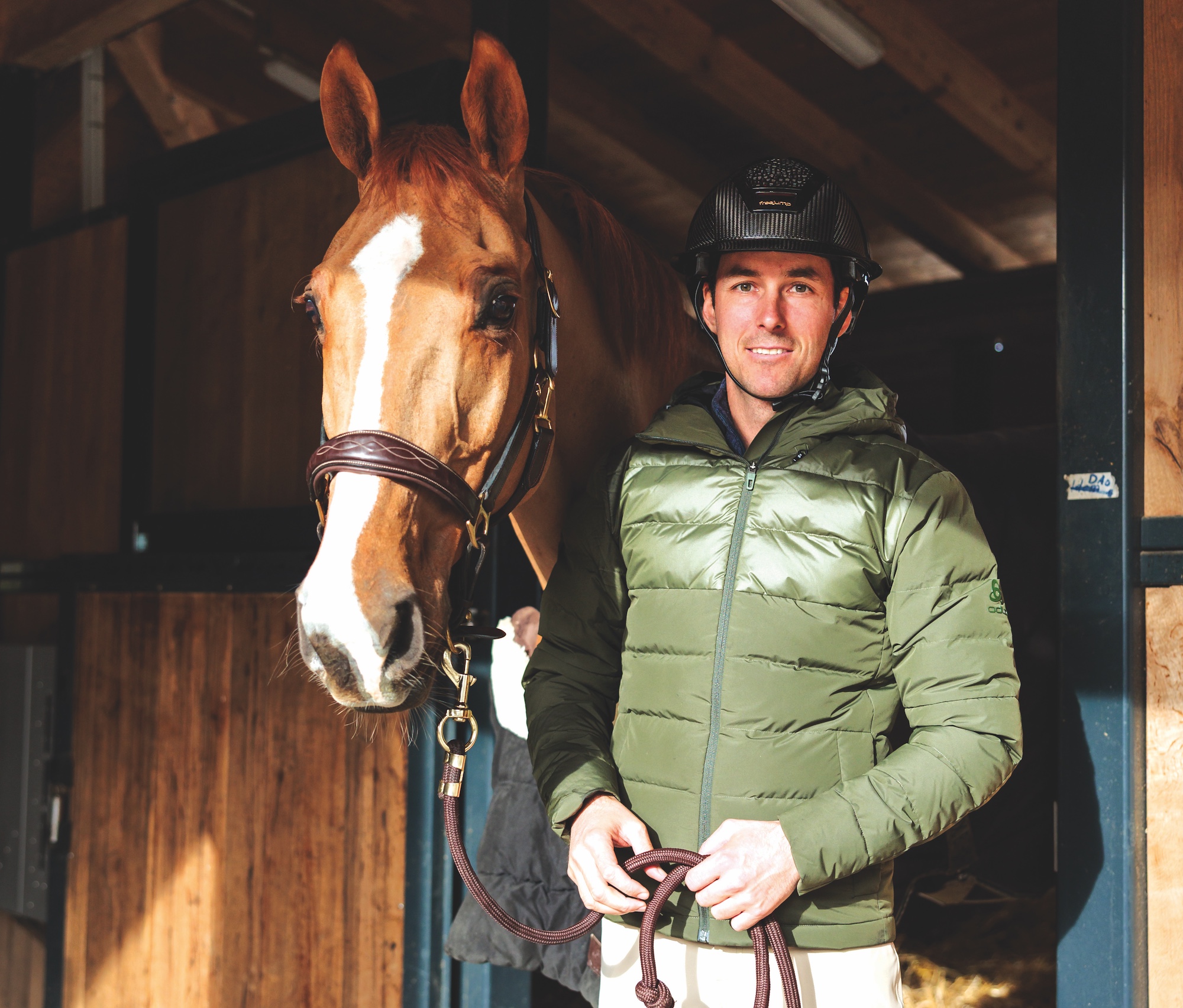 Chestnut horse in stable with rider.