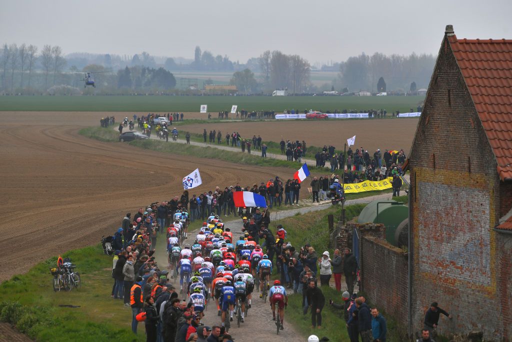 The peloton races through sector 13 at Orchies