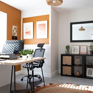 white home office with orange colour blocking industrial desk and black chair rattan pendant light orange rug
