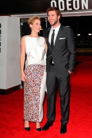 Jennifer Lawrence poses with Liam Hemsworth at the The Hunger Gamespremiere