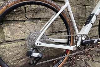 Rear triangle of the Fara F/Gravel bike close up with a muddy wheel