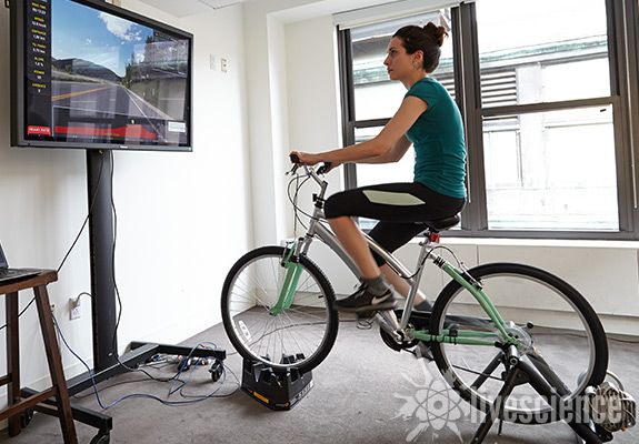 a woman is riding an indoor bike.