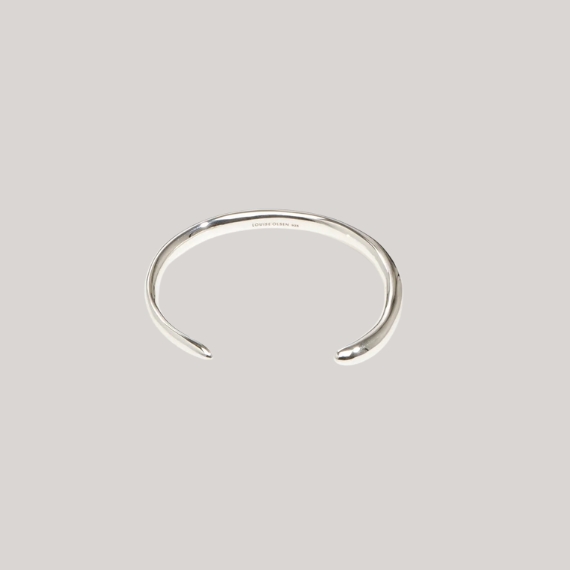 A silver wrist cuff against a pale gray background.