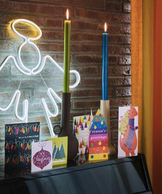 An angel LED light with Christmas cards and candlesticks in candlestick holders