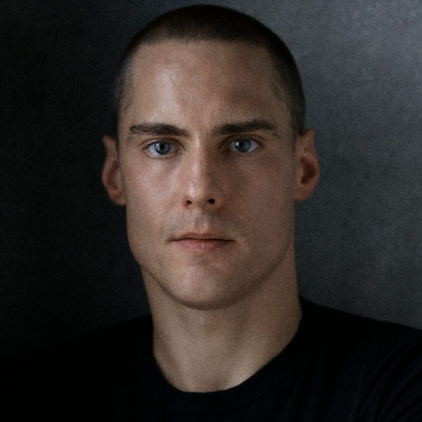 A headshot of a man with cropped hair