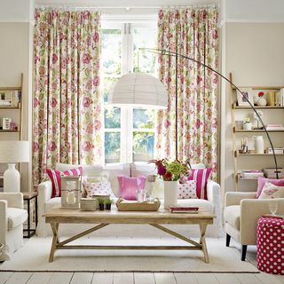 living room with floral curtains sofa and cushions
