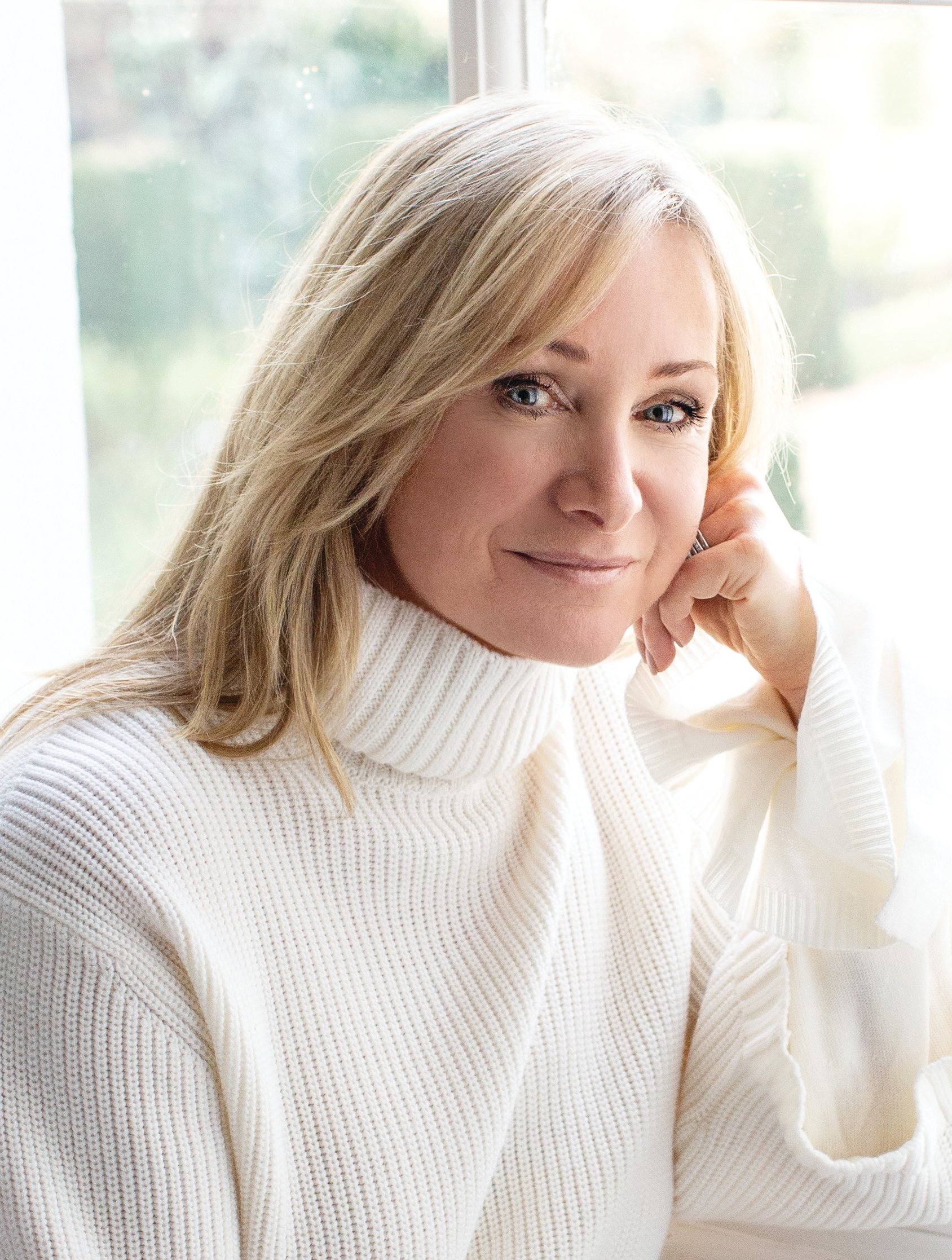 image of Chrissie Rucker, owner of The White Company, a blond woman wearing a white sweater
