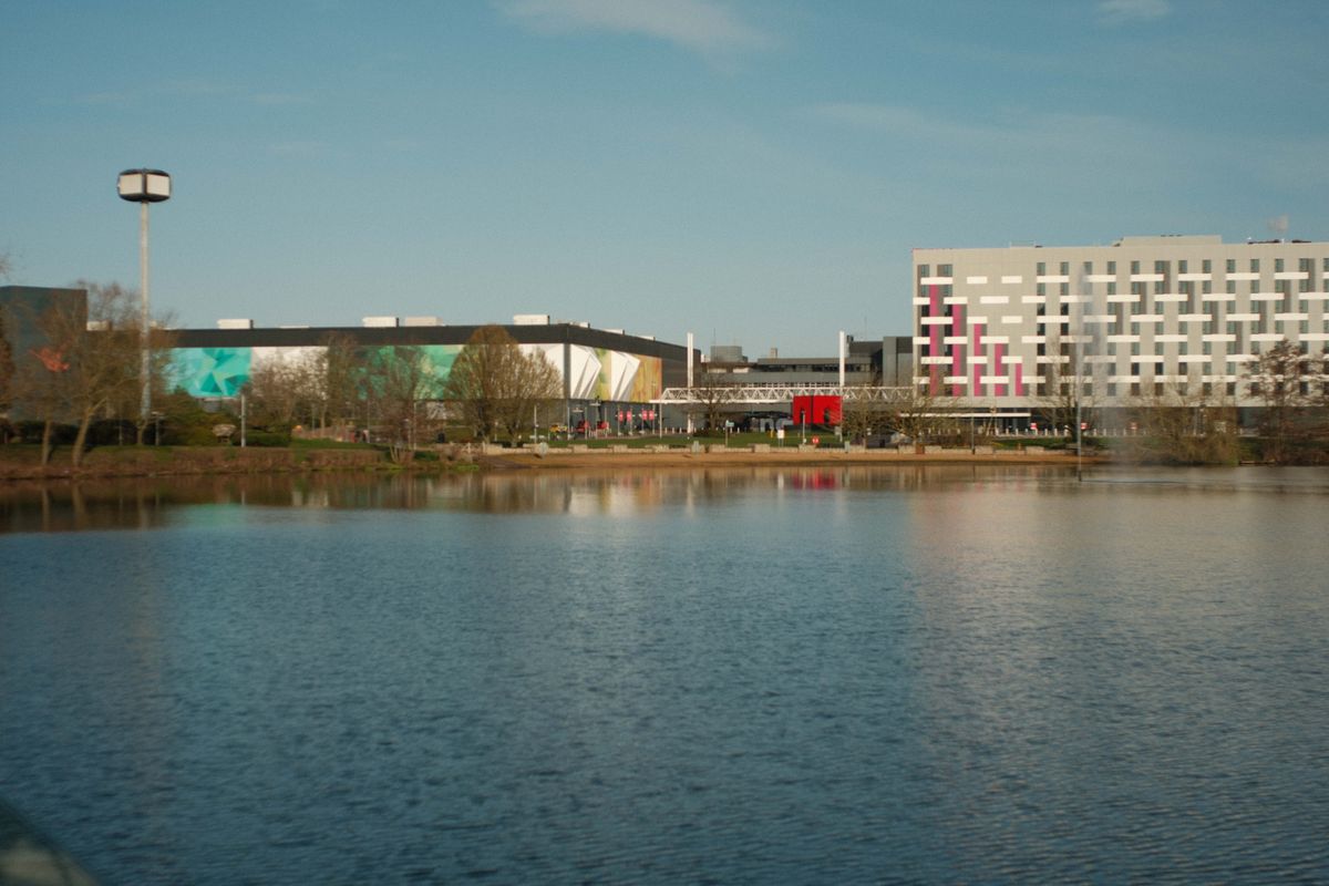 Buildings reflected in a lake seen from a moving train