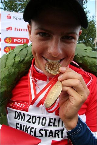 Jakob Fuglsang (Team Saxo Bank) takes a bite out of his new medal.