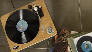 House Of Marley Stir It Up Wireless Turntable beside record collection