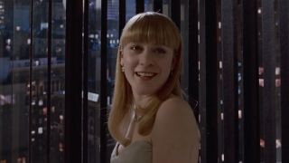 Jean smiling in fancy dress looking out at city in American Psycho