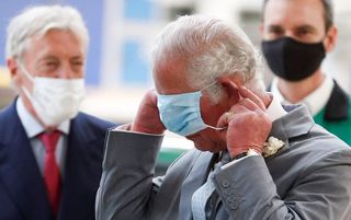 Prince Charles, Prince of Wales, puts on a face covering due to Covid-19, after making a speech to employees during his visit to the MINI plant in Oxford on June 8, 2021
