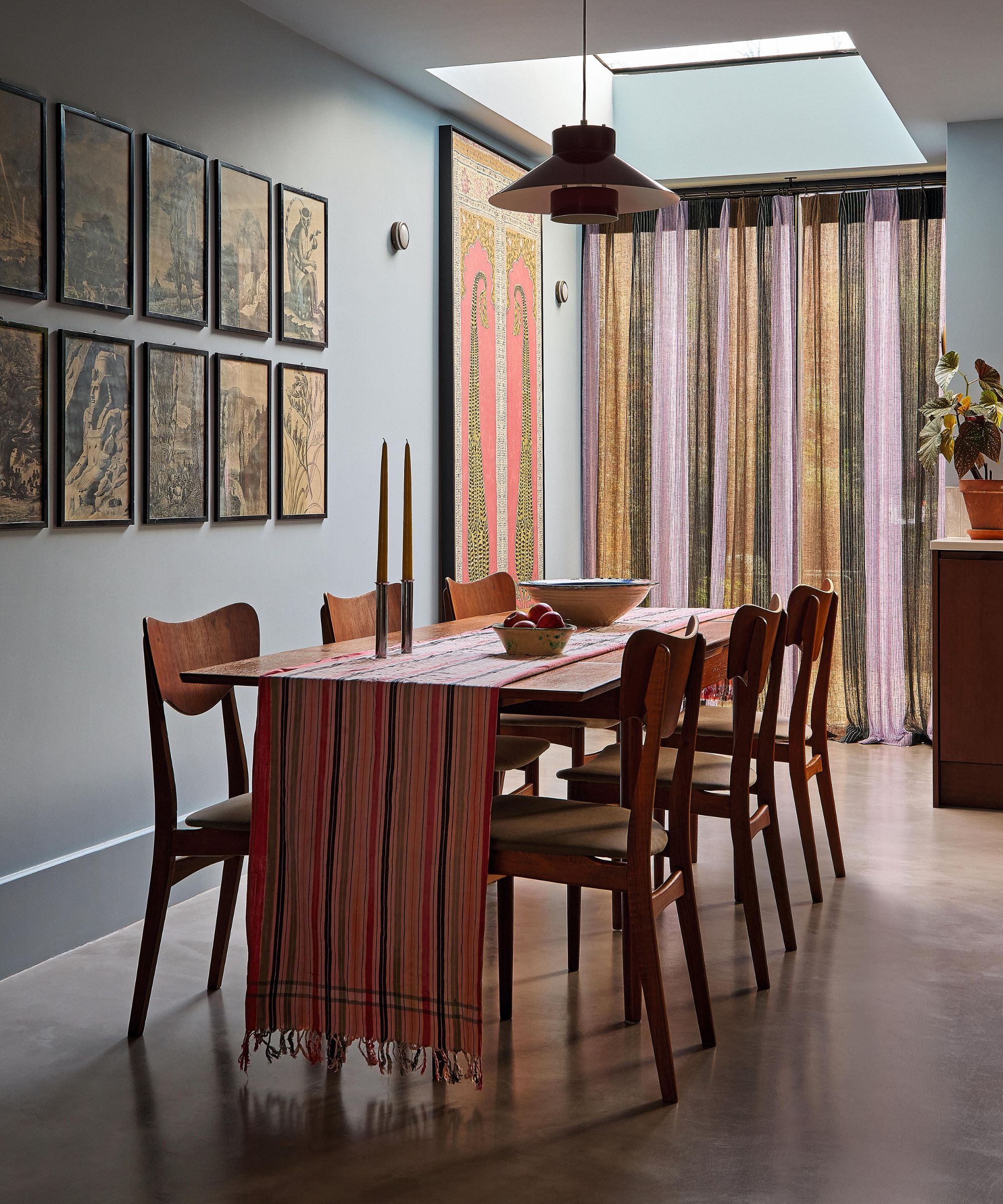 a blue london dining room with danish vintage table and chairs and a red striped table runner. at the end of the room are external double doors wit striped drapes