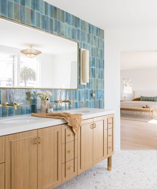 Bathroom with blue wall tiles and wooden vanity cabinet