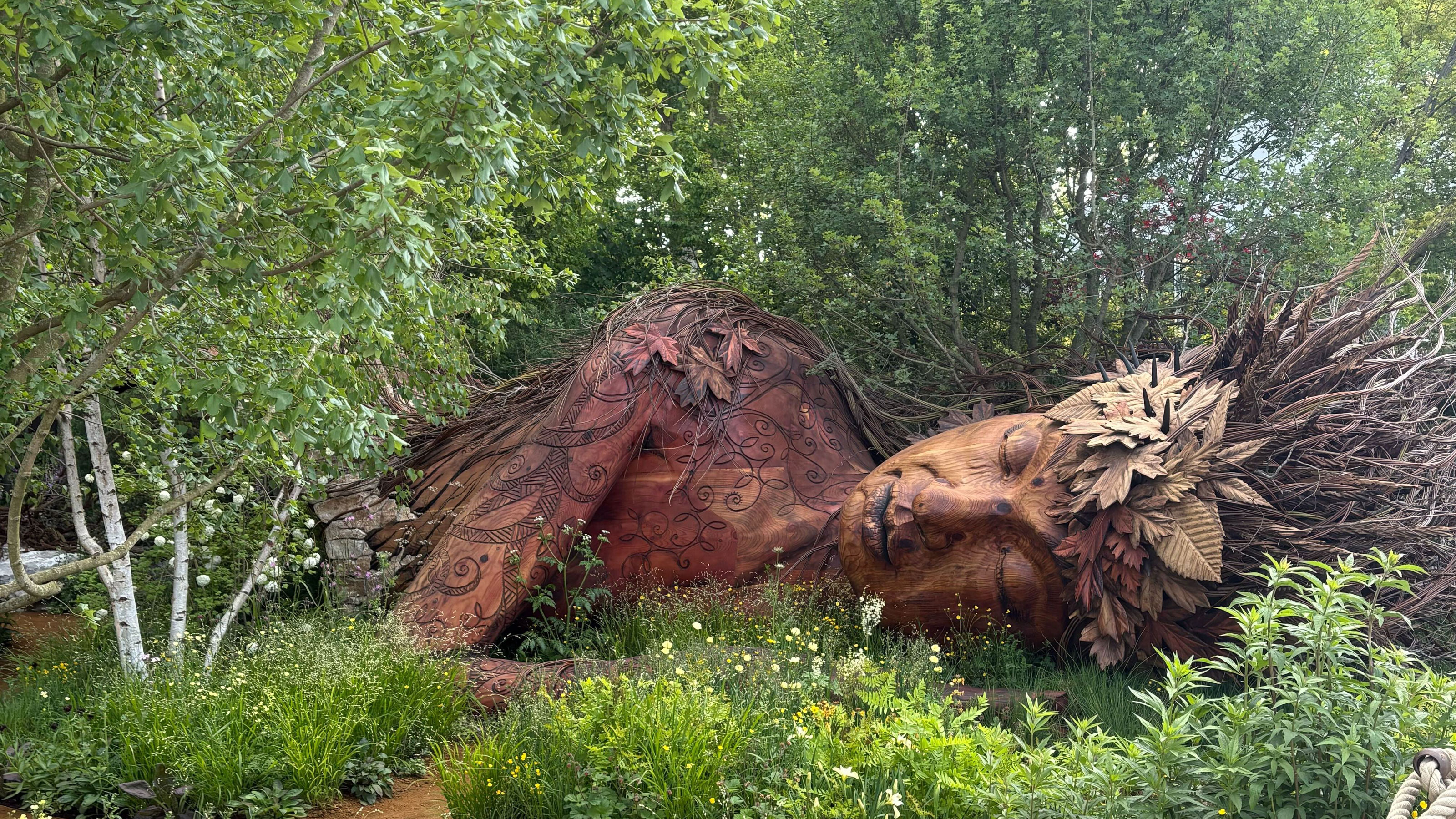 Wooden sleeping woman structure with greenery around